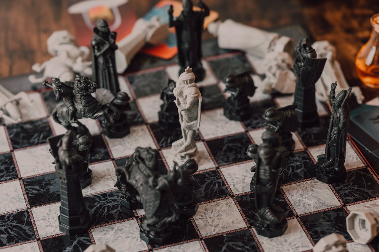 Close-up of intricately designed chess pieces on a marble-patterned board.