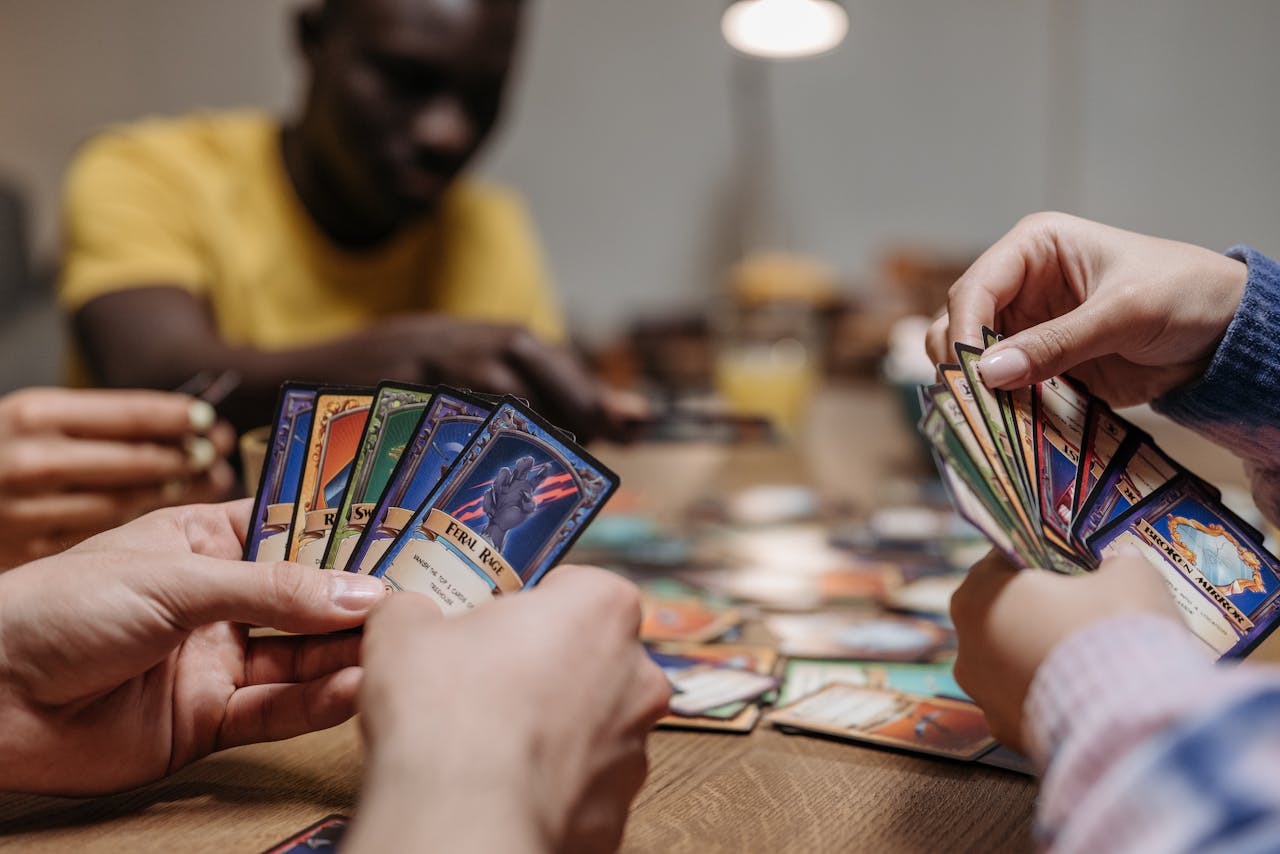 Adults playing a strategy card game together, showcasing teamwork and fun indoors.